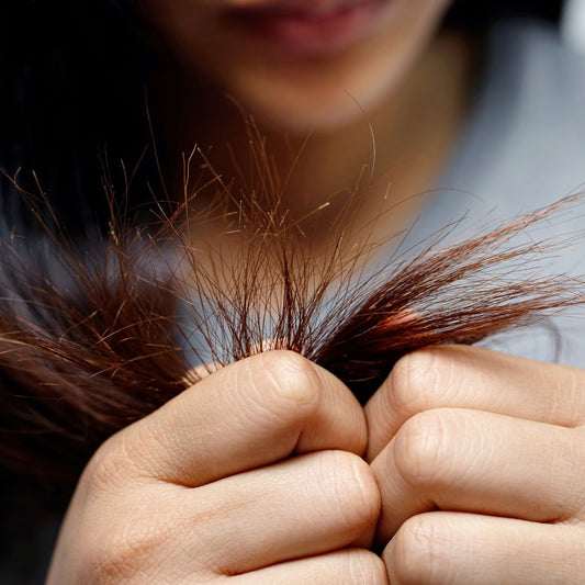 Woman holding her hair that has lots of split ends.