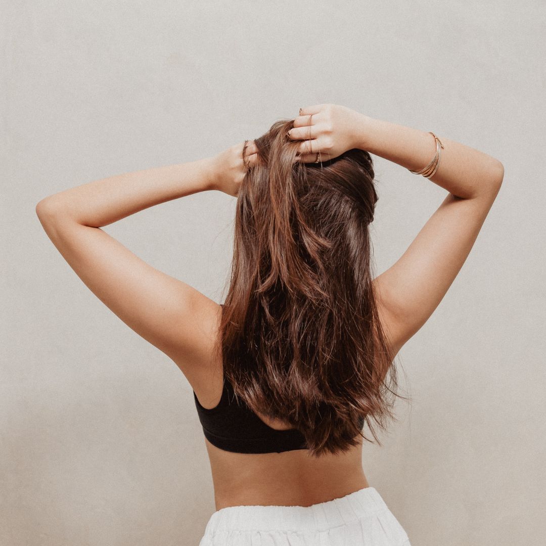 Woman with her hands up, touching her hair